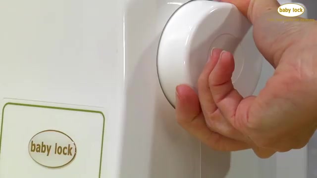 Carefully rock the flywheel backwards until you can lift the needle up from the fabric.