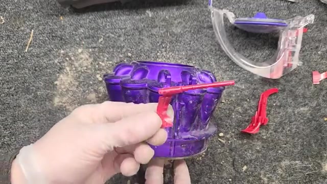Locate the red actuator arm with its spring.