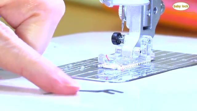 Turn the flywheel to access the needle area.
