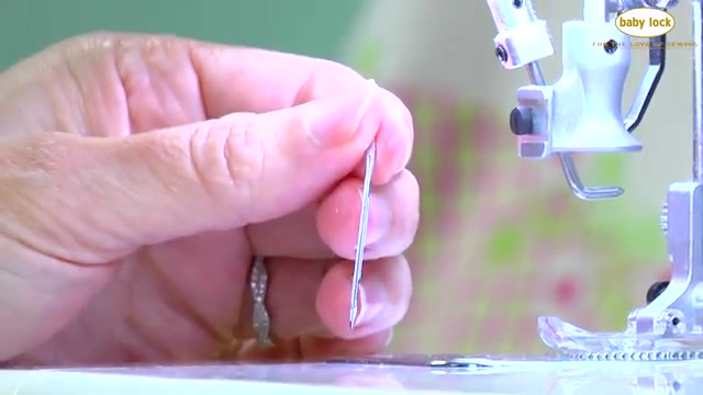 Loosen the needle screw while holding the needle.